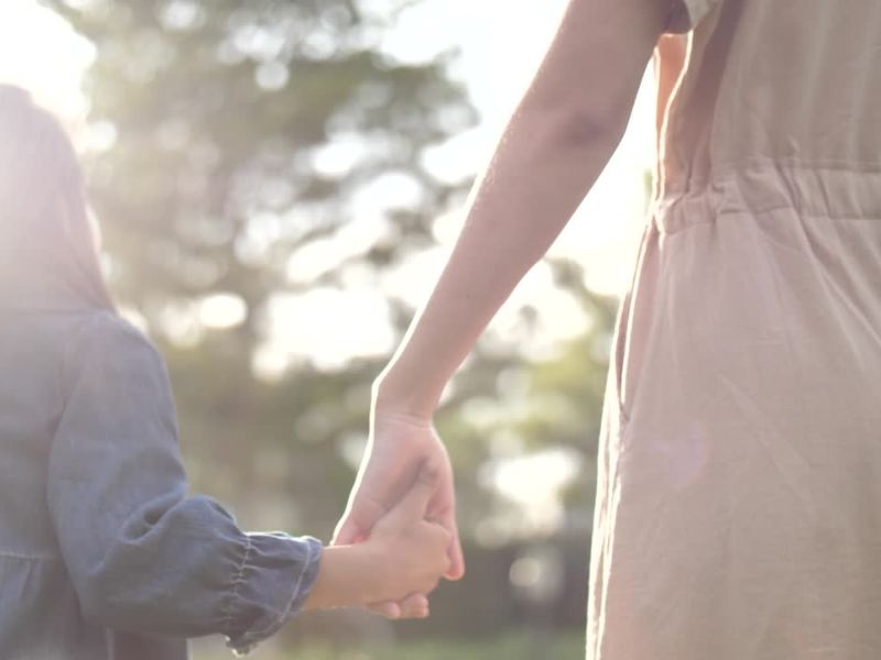 majka i ćerka se drže za ruke i šetaju